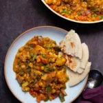 plate of vegetable bhuna next tot he pan, naan on the side for dipping