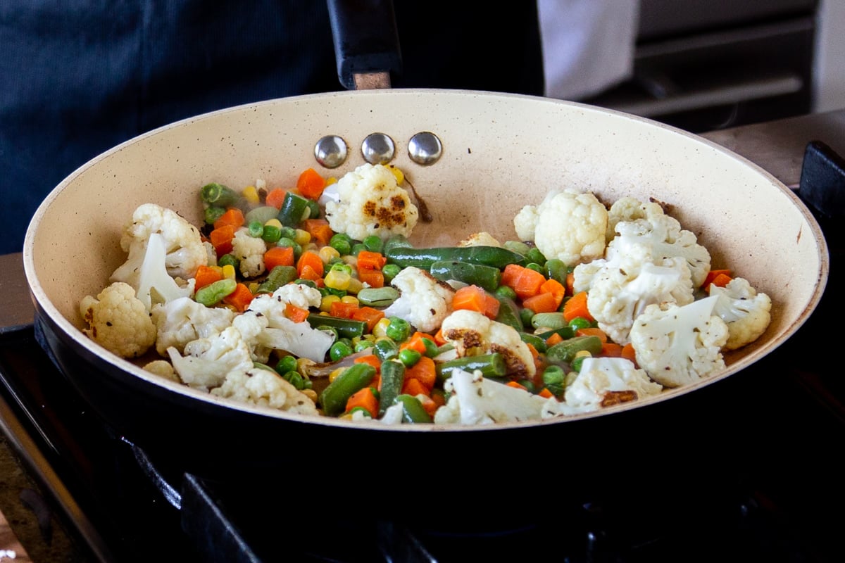 adding the rest of the vegetables to the cauliflower