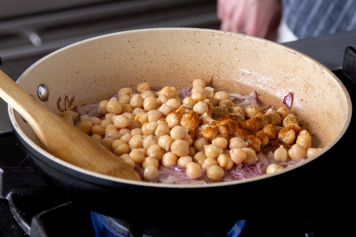 adding chickpeas and spices to the pan