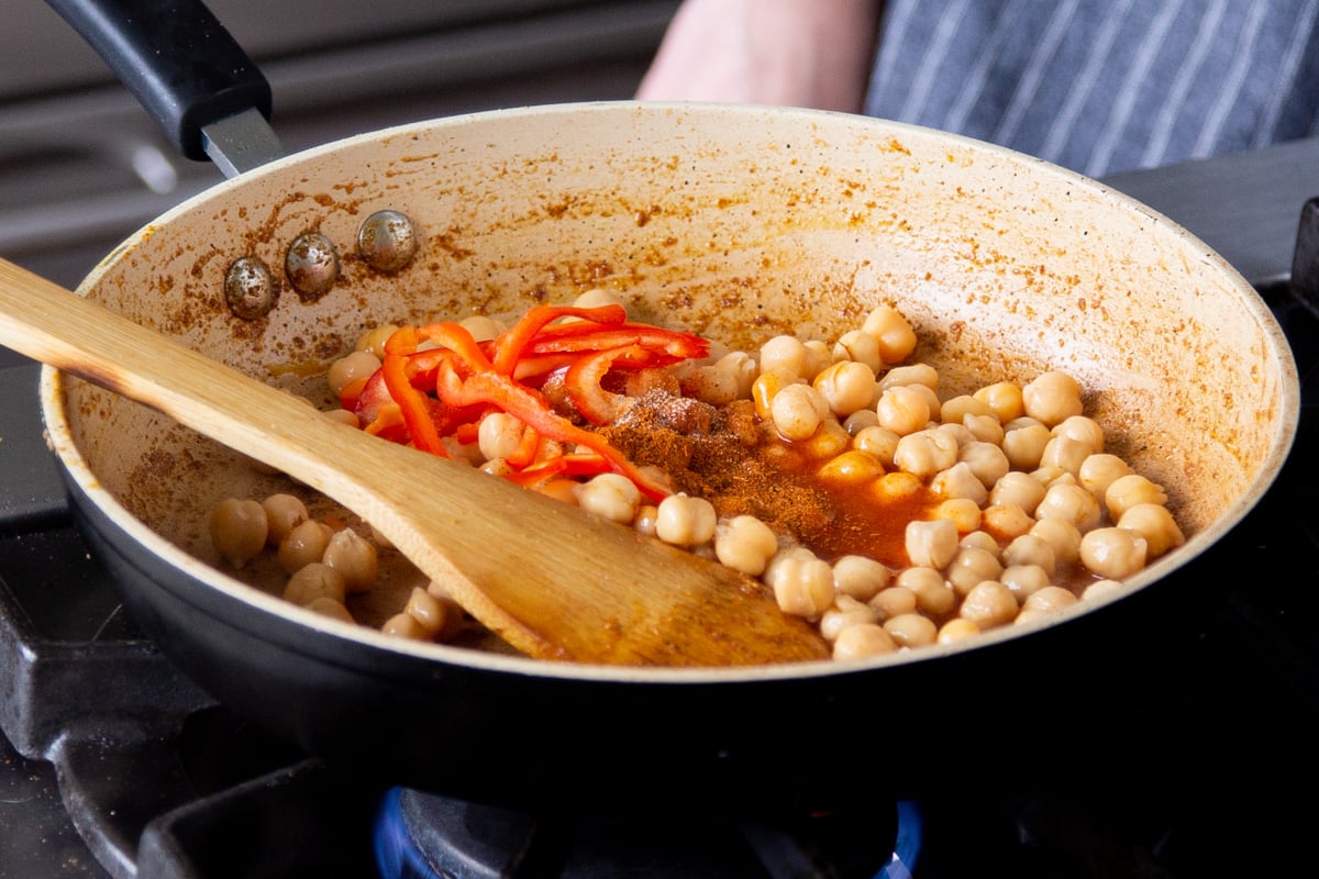 chickpeas, bell peppers, spices, and buffalo sauce in the pan