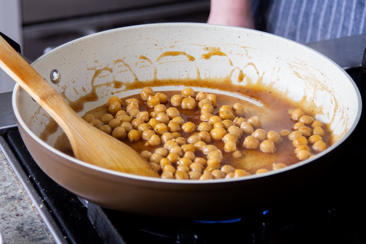 adding chickpeas to the lemon pepper sauce in the pan