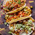 overhead photo of chickpea tacos with different fillings and toppings on the kitchen counter