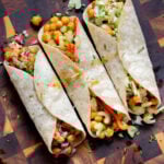overhead photo of chickpea wraps with different fillings and toppings on the kitchen counter
