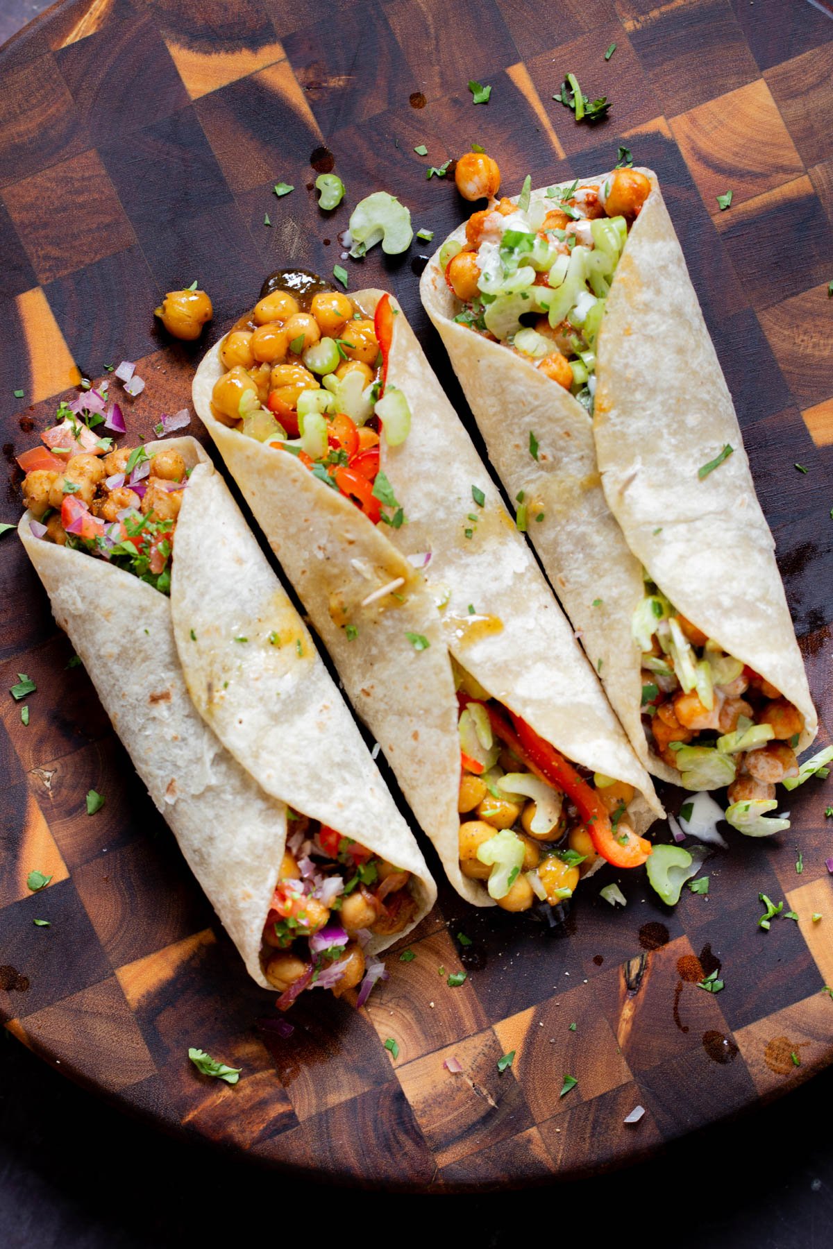 overhead photo of chickpea wraps with different fillings and toppings on the kitchen counter