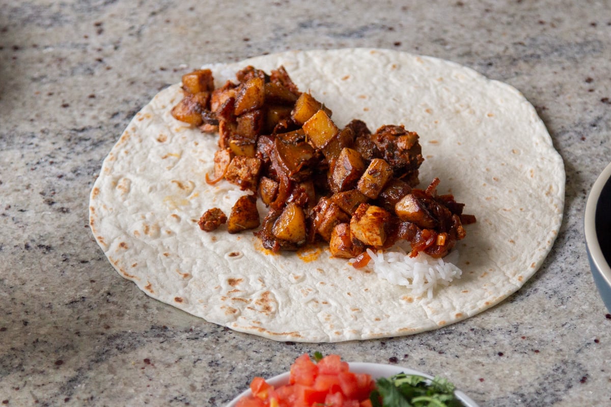 adding the tofu and potato mixtures to the tortilla