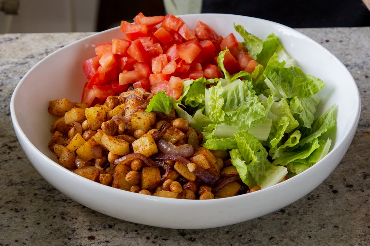 adding tomato to the salad