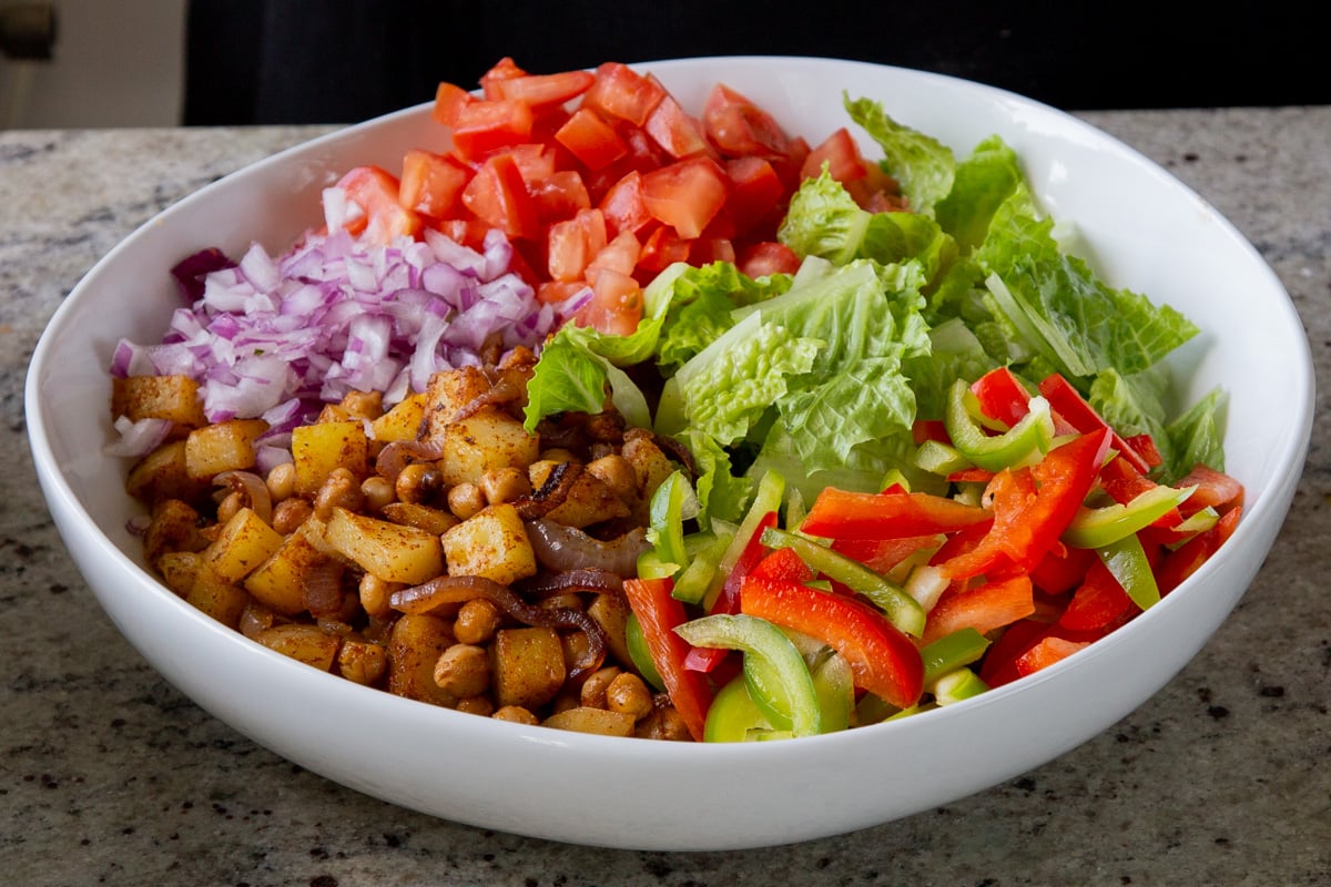 adding red onion to the salad bowl