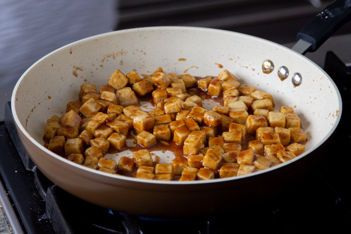 tofu tossed in the lemon pepper sauce in the pan