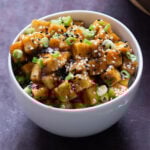 bowl of lemon pepper tofu topped with sesame seeds and green onions