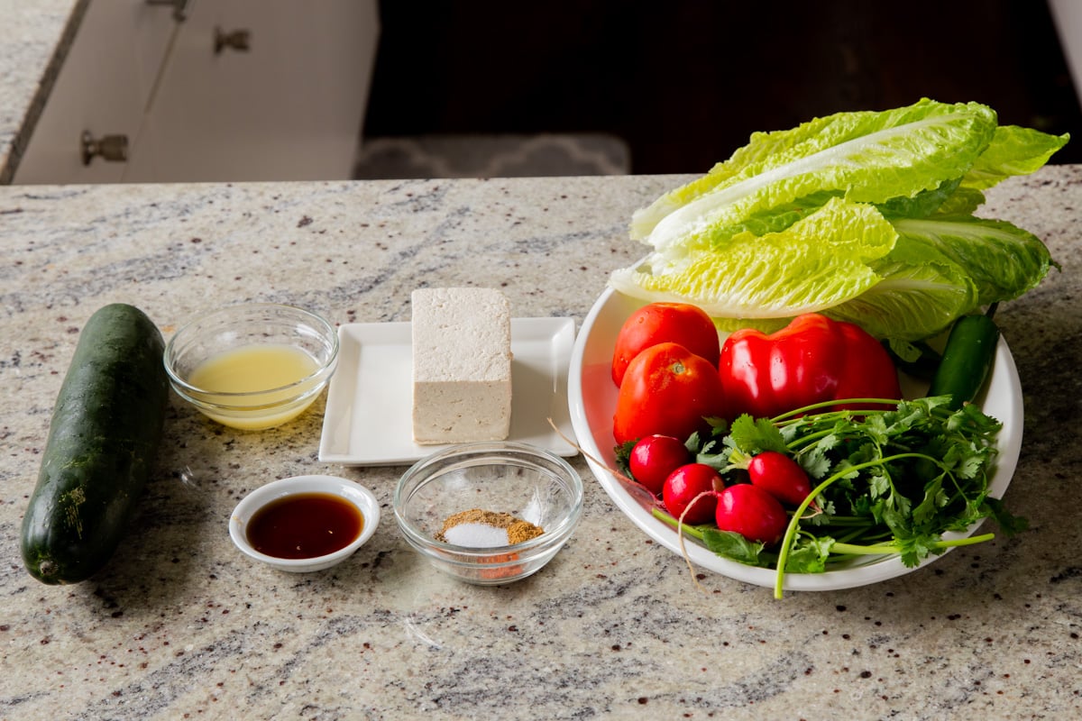 tofu, veggies, and chaat masala dressing ingredients in bowls on a kitchen counter
