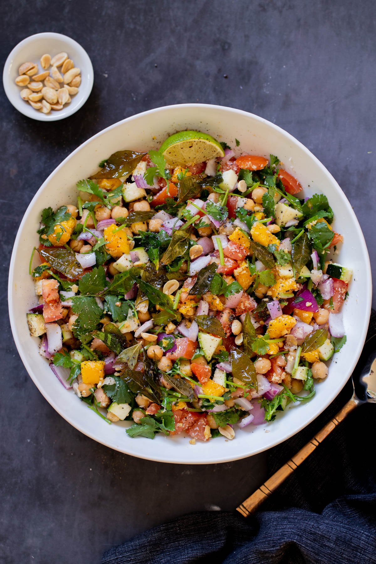 zucchini koshimbir salad in a serving bowl with a lime wedge