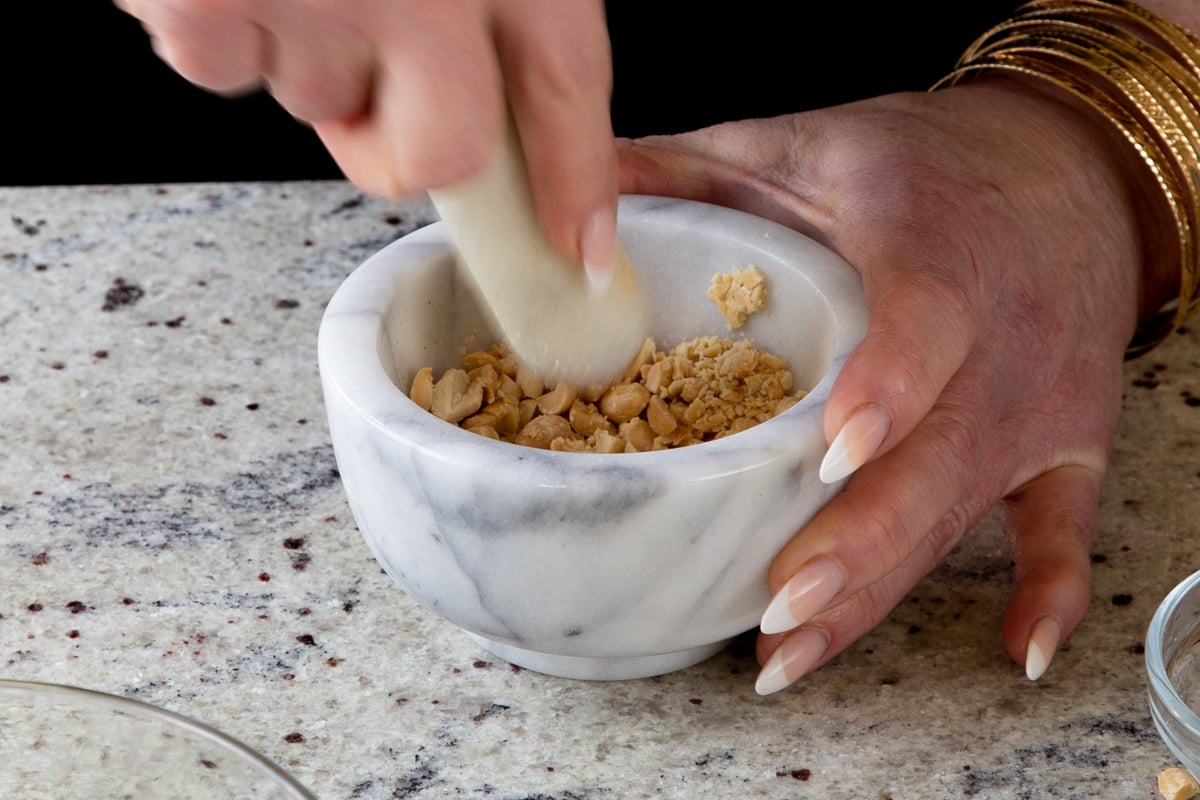 crushing peanuts with a mortar and pestle
