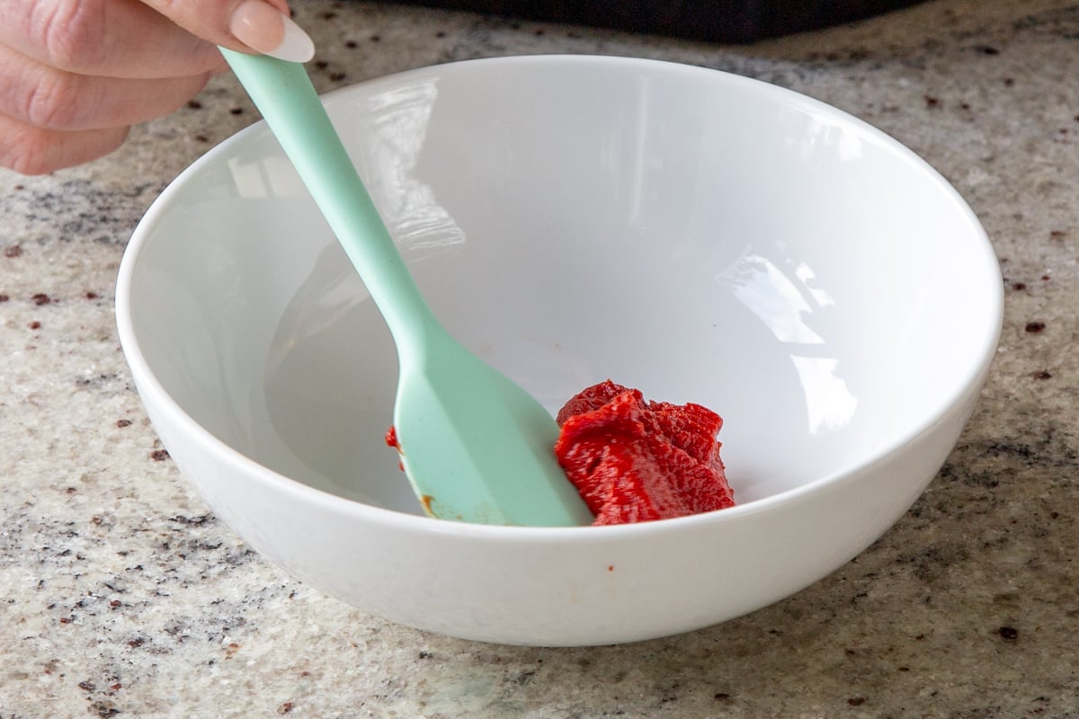 tomato paste in a bowl with a spatula