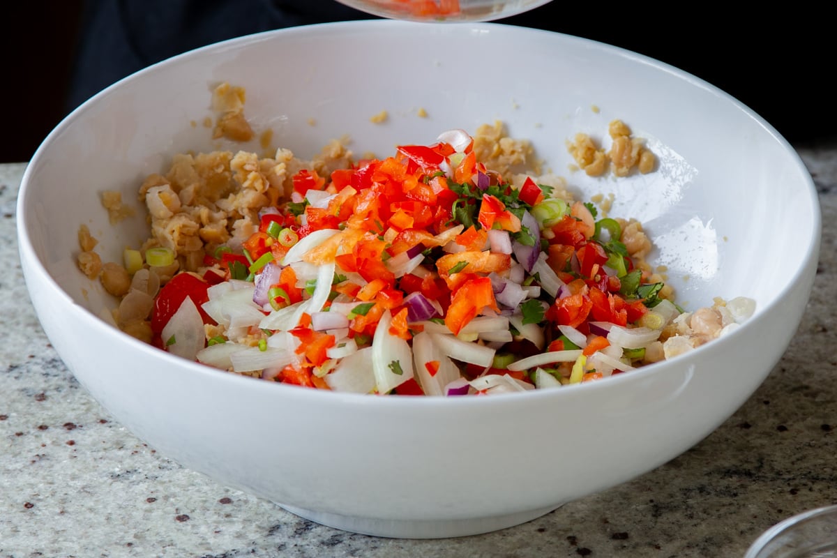 adding the crunchy veggies to the mashed chickpeas