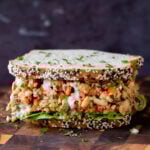 cajun chickpea salad in a sandwich with lettuce and a sprinkle of cilantro
