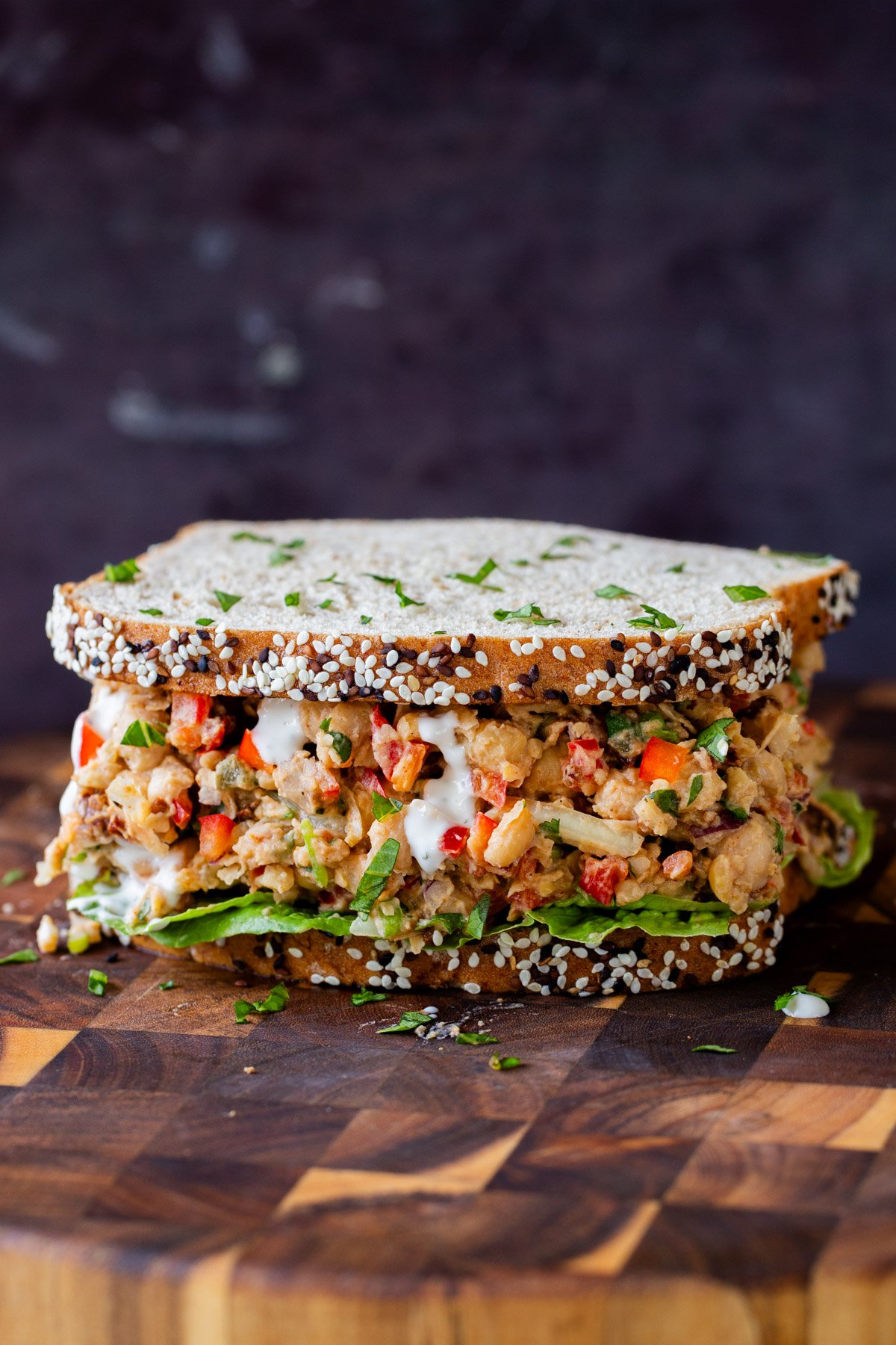 cajun chickpea salad in a sandwich with lettuce and a sprinkle of cilantro