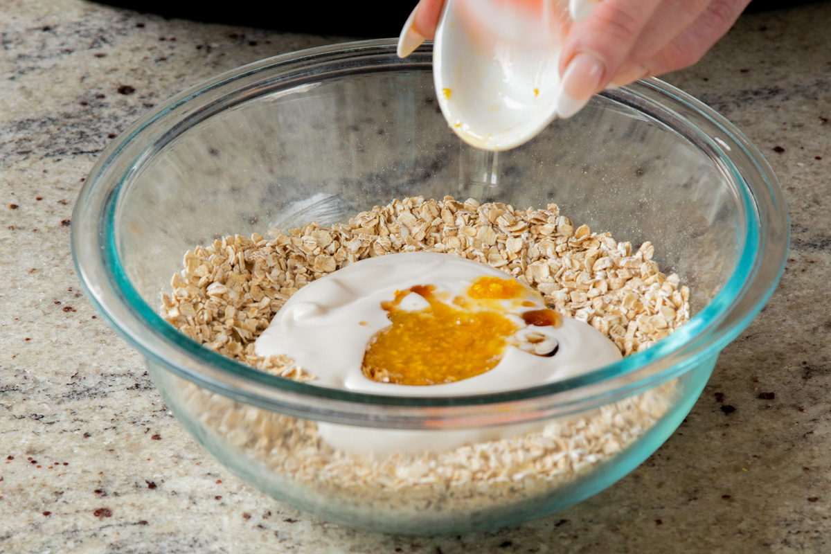 adding yogurt, maple syrup, and orange zest to the dry oat mixture