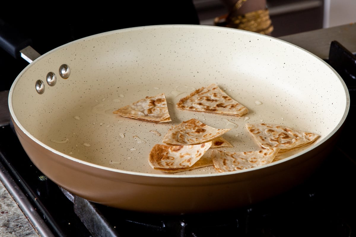 tortilla pieces in the hot frying pan