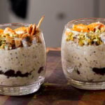 glasses full of cannoli overnight oats topped with oranges, pistachios, and crispy cinnamon sugar tortilla pieces, so you can see the chocolate chips layer