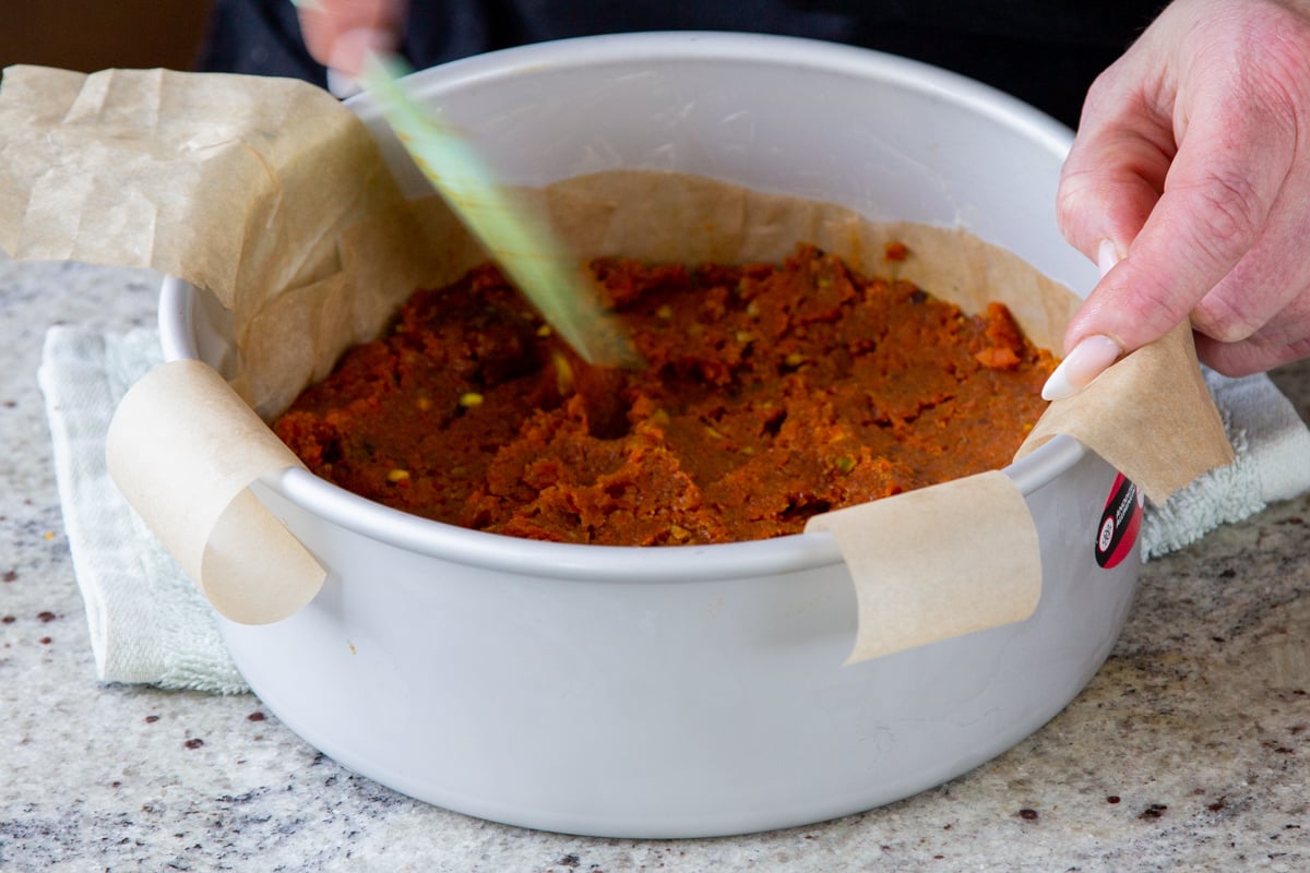 pressing carrot halwa layer into the pan