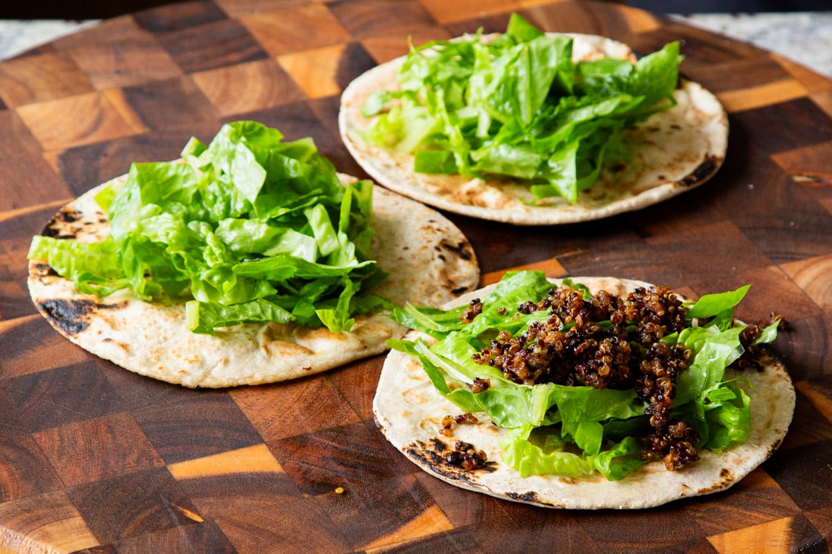 adding lettuce to tortillas