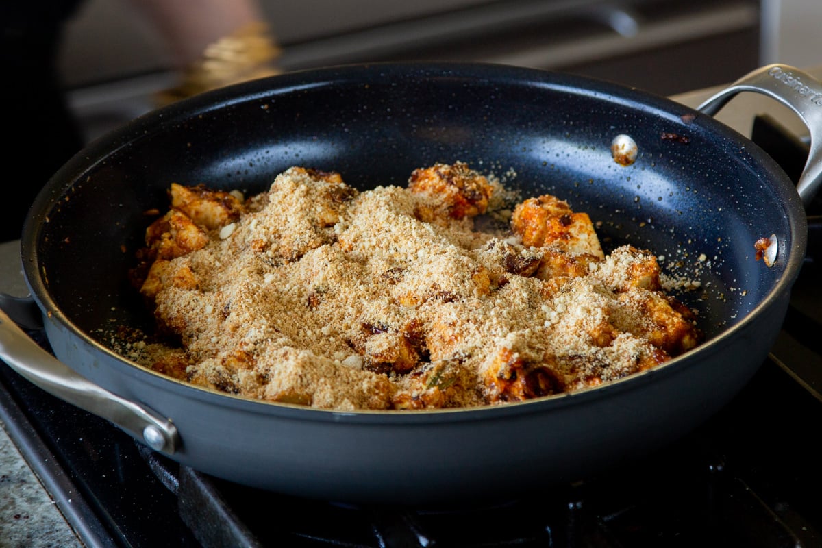 adding the toasted coconut-almond mixture to the tofu