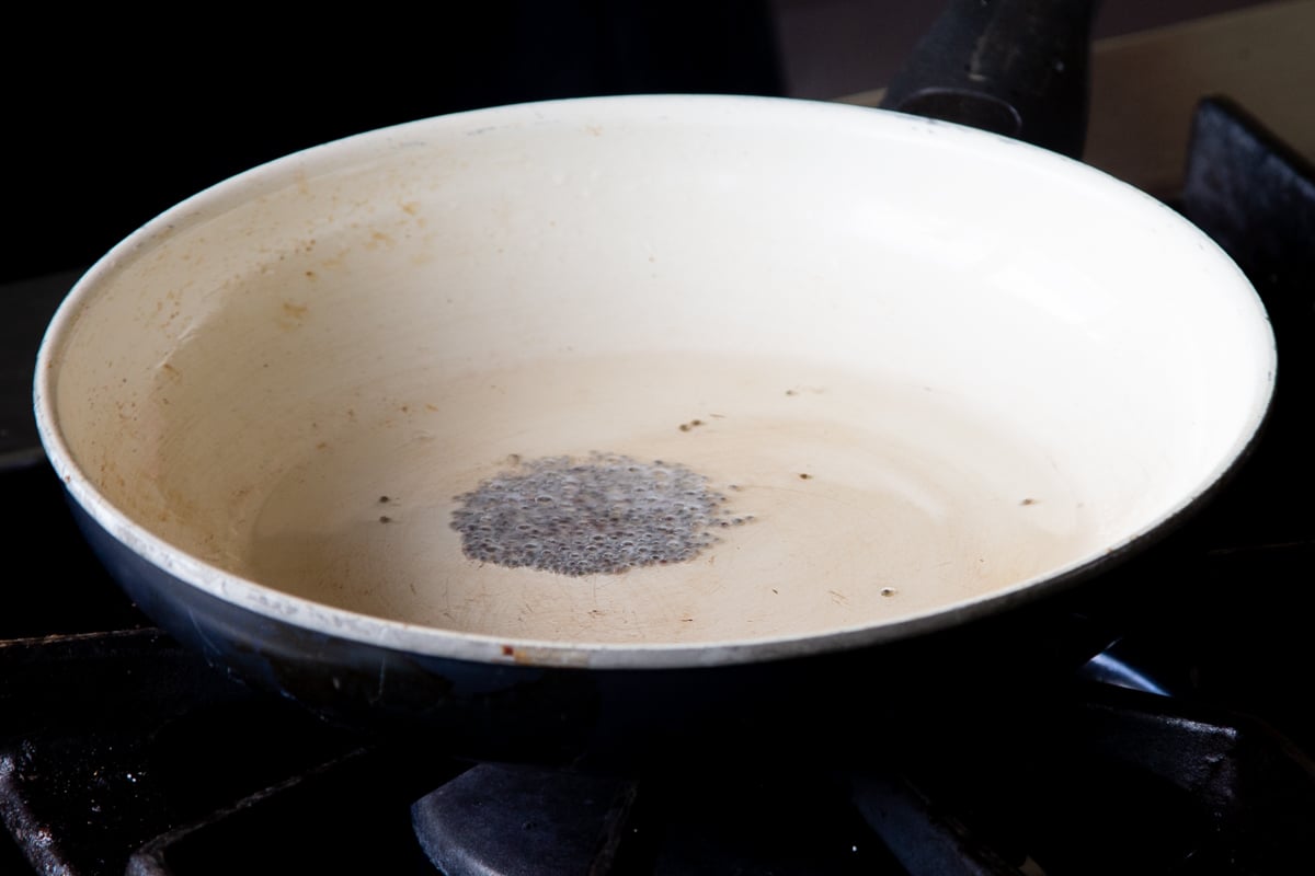 toasting the mustard seeds in a hot pan of oil
