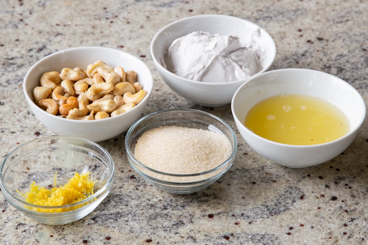 cashews, coconut cream, and other pudding ingredients in bowls on a kitchen countertop