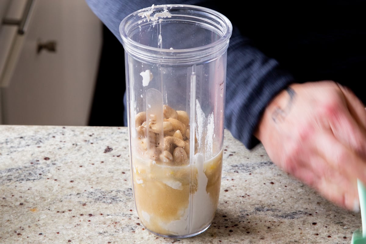 cashews added to the blender of pudding ingredients