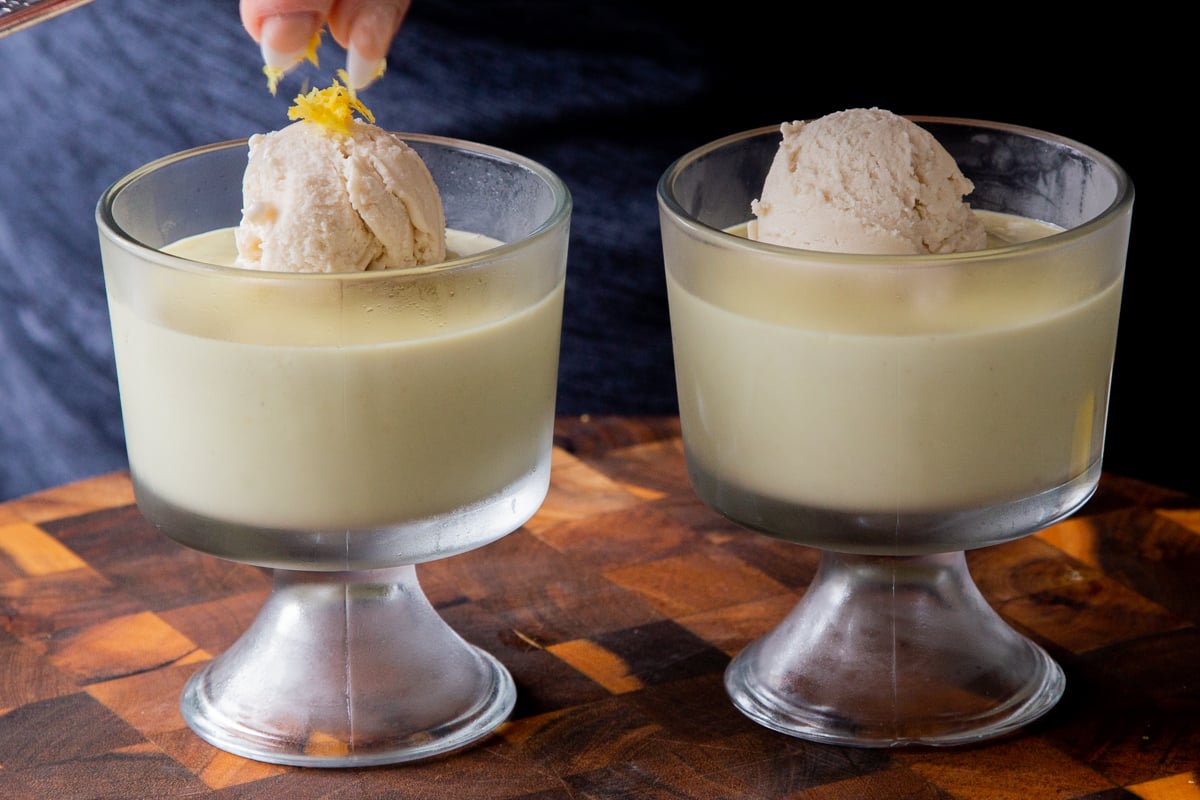 adding lemon zest to vanilla ice cream on top of cups of vegan lemon pudding