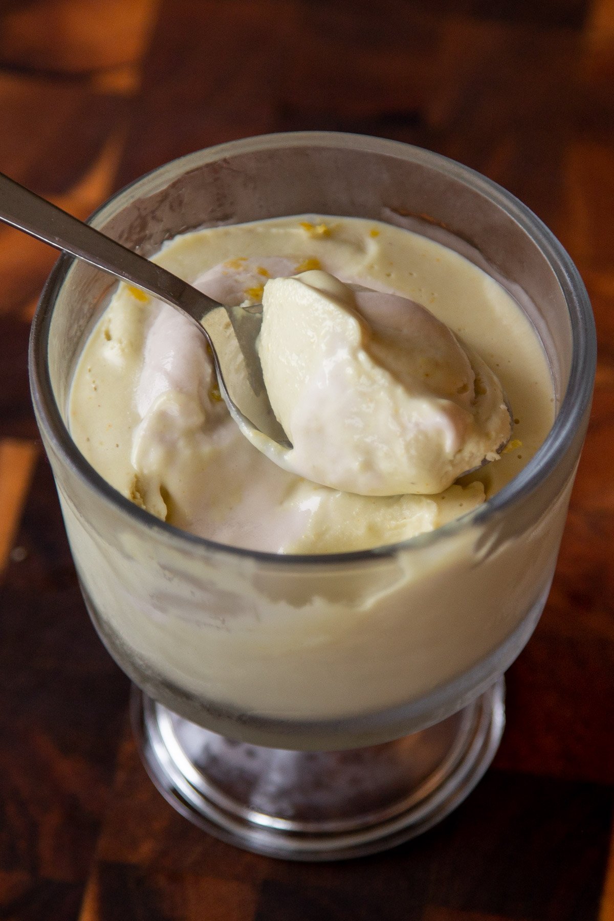 cup of lemon pudding with a spoonful resting on top of it