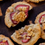 close-up of a strawberry cheesecake cookie broken in half on a wooden serving tray