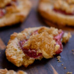 close-up of strawberry cheesecake cookie with a bite taken out, so you can see the inside