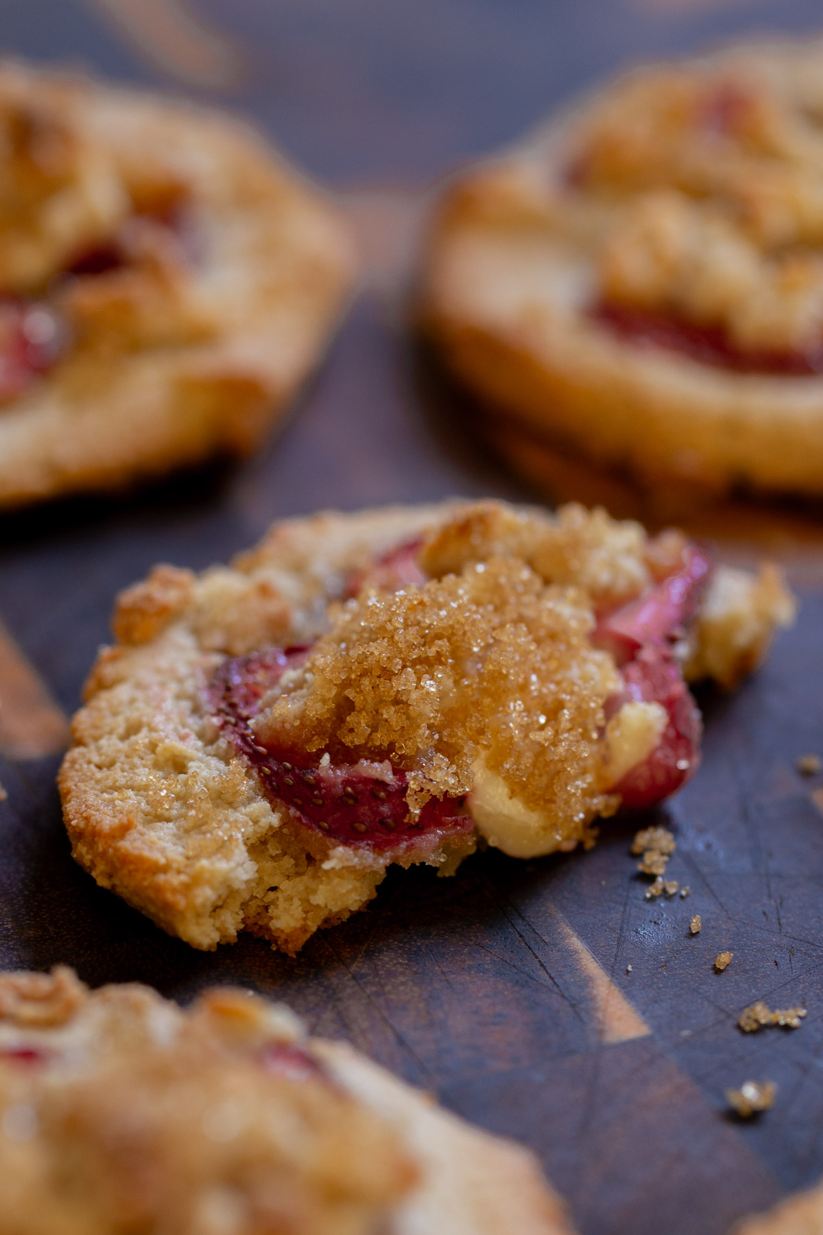 close-up of strawberry cheesecake cookie with a bite taken out, so you can see the inside