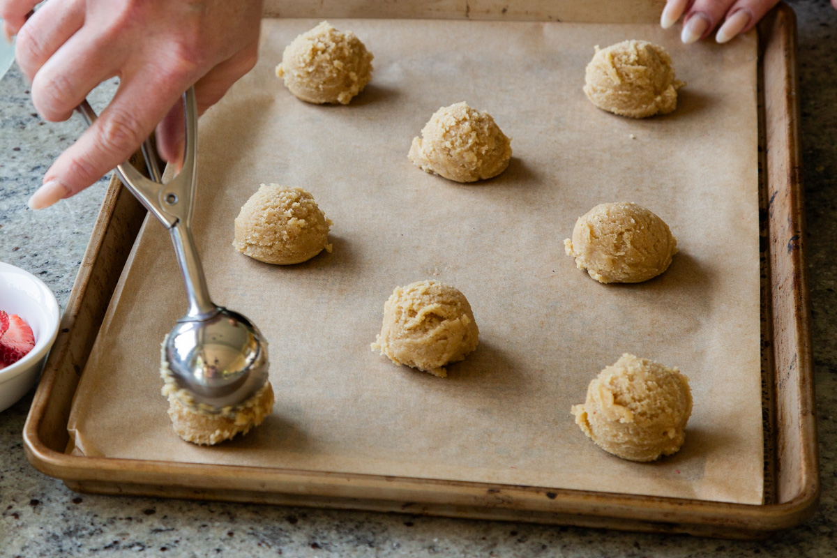 scooping chilled cookie dough onto the baking sheet