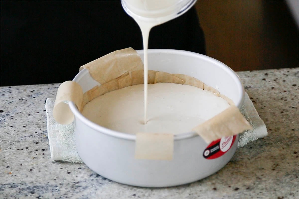 pouring cheesecake mixture into the pan