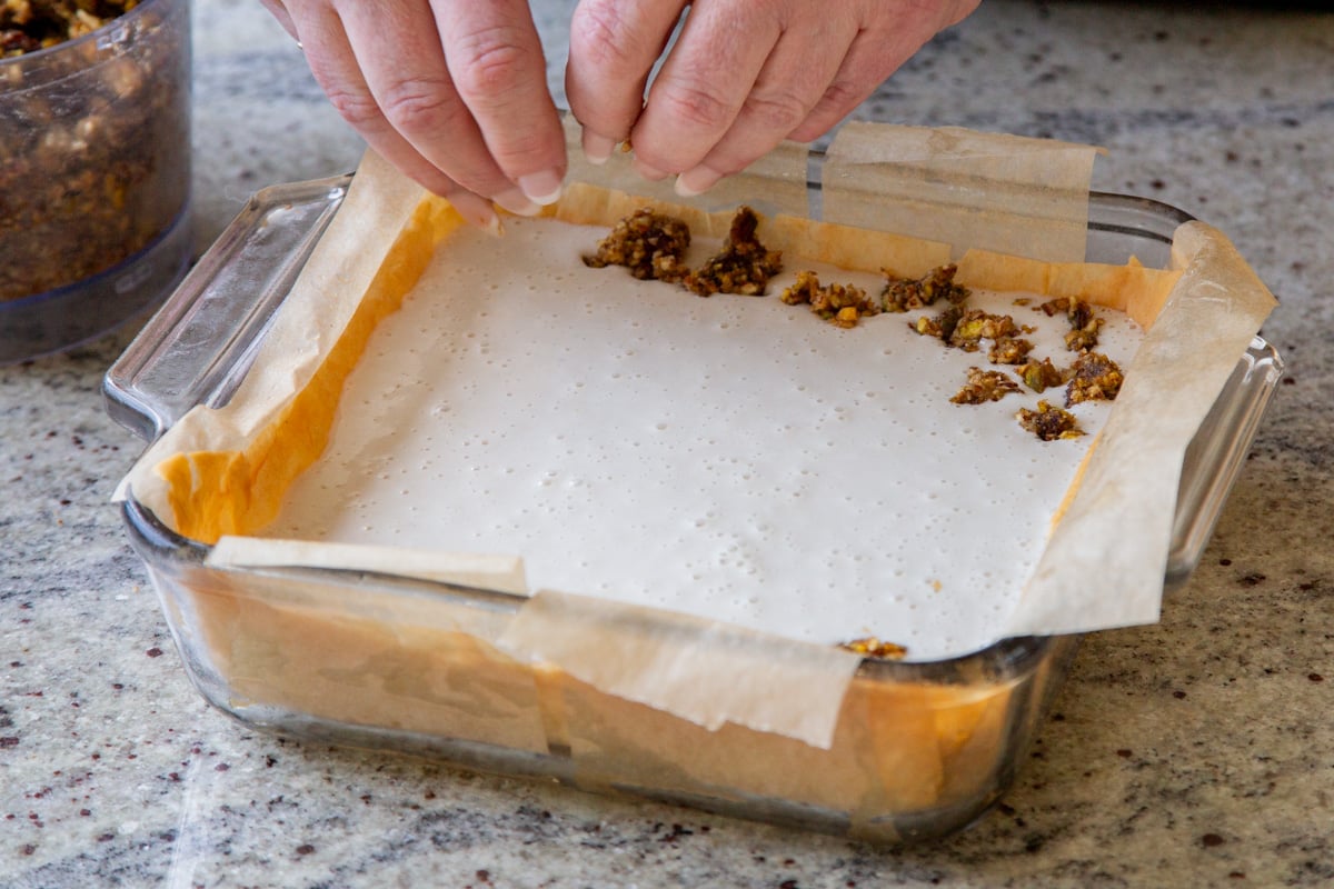 crumbling the date-nut mixture over the cheesecake layer