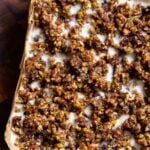 baklava cheesecake on a wooden cutting board, before slicing