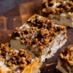 side view of baklava cheesecake on a wooden cutting board