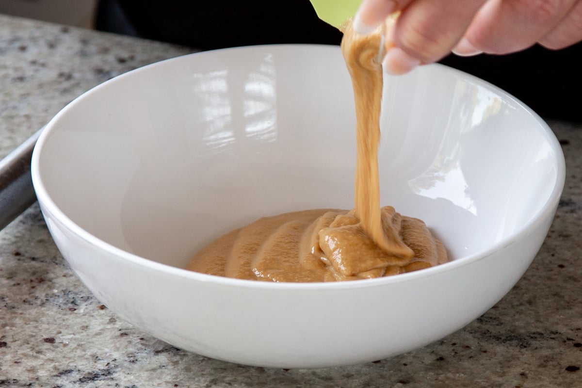 adding tahini to a bowl