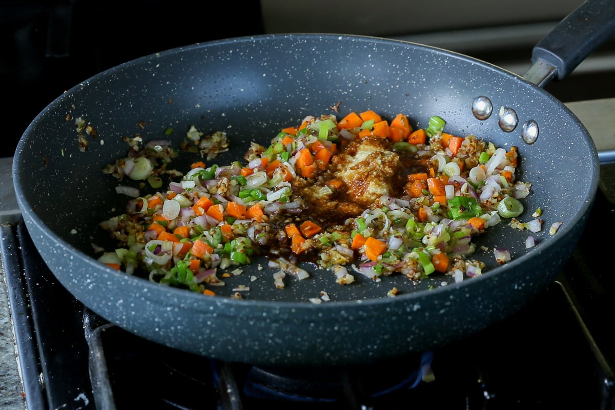 adding ginger-garlic paste to the pan of veggies