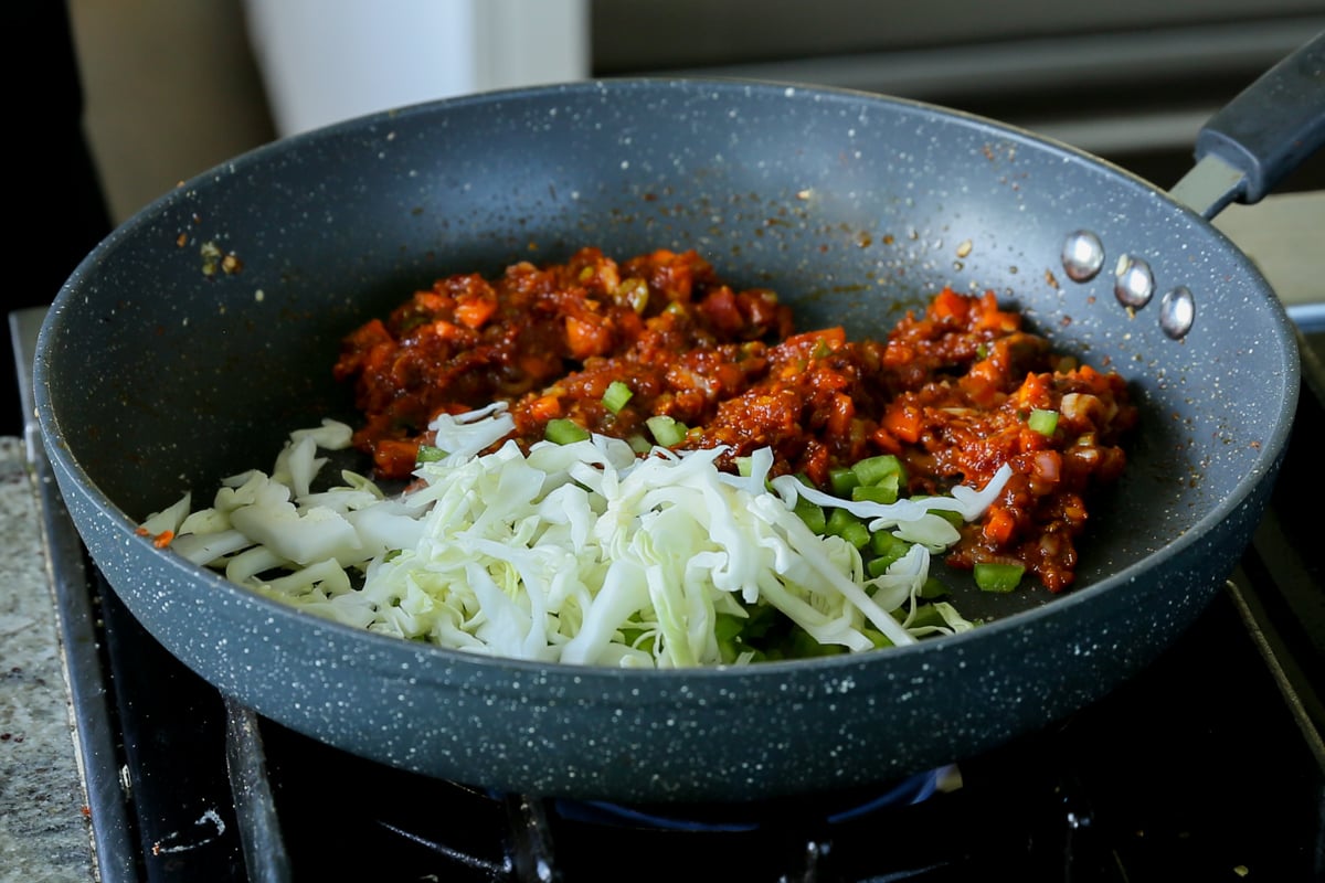 adding cabbage to the pan