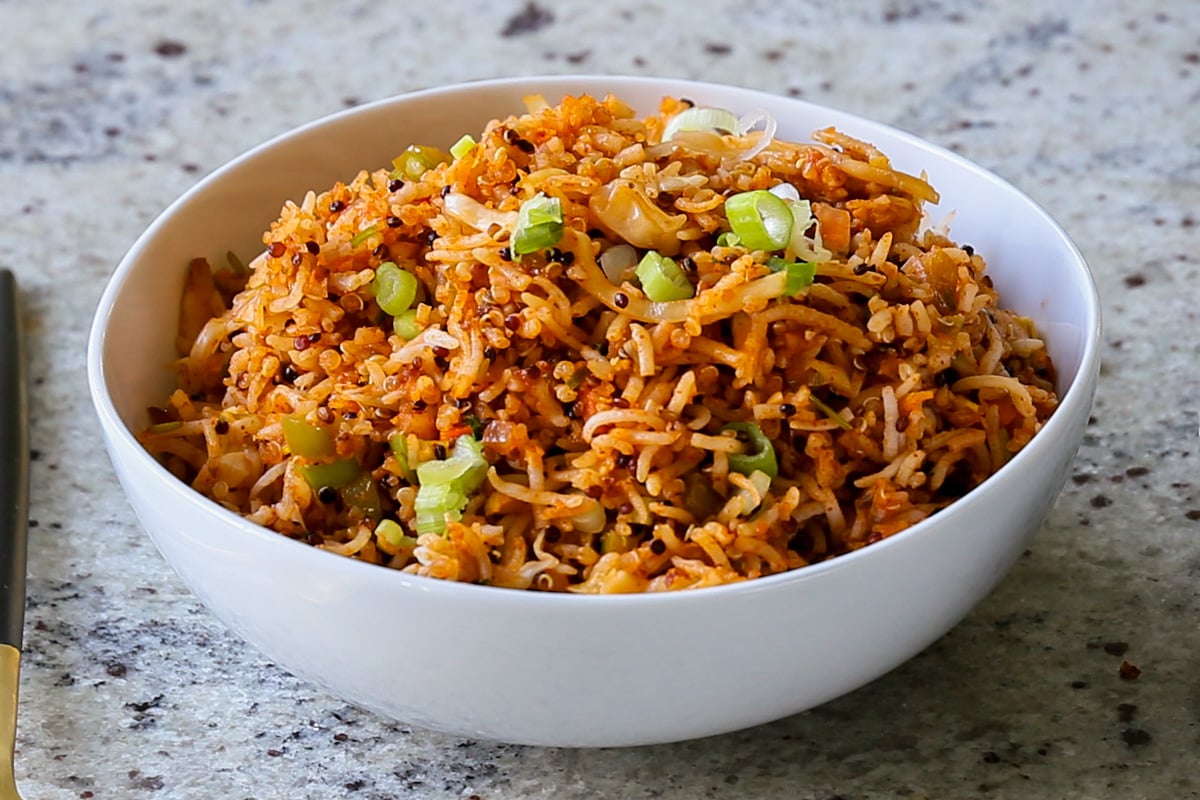 Schezwan fried rice in a bowl with green onions for garnish