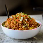 Schezwan fried rice in a bowl with green onions for garnish