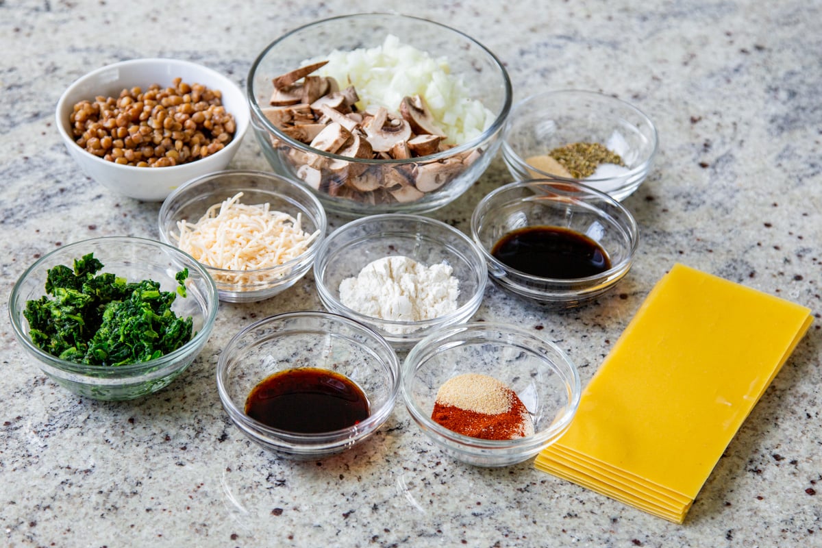 lentils, lasagna sheets, and other skillet lasagna ingredients in bowls on a kitchen counter
