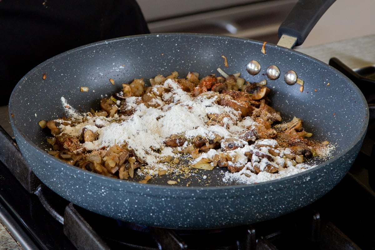adding flour to the cooked mushrooms and onions