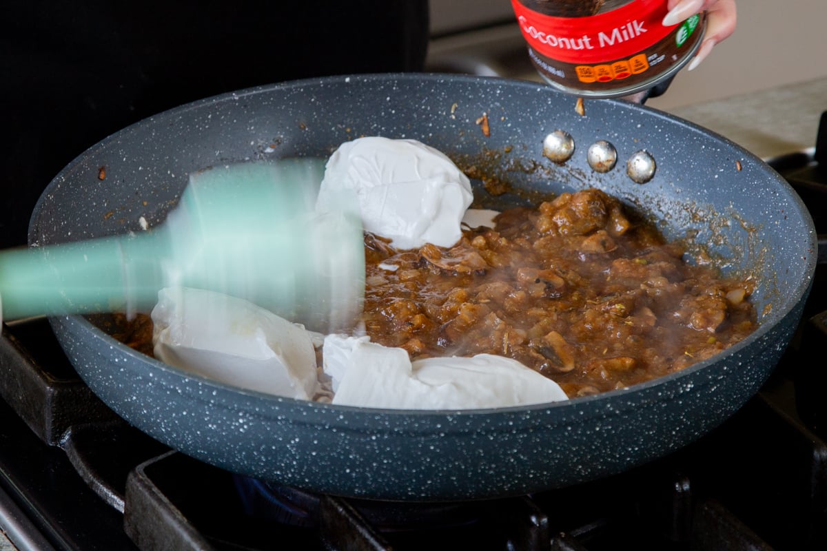adding coconut milk to the mushroom-onion mixture