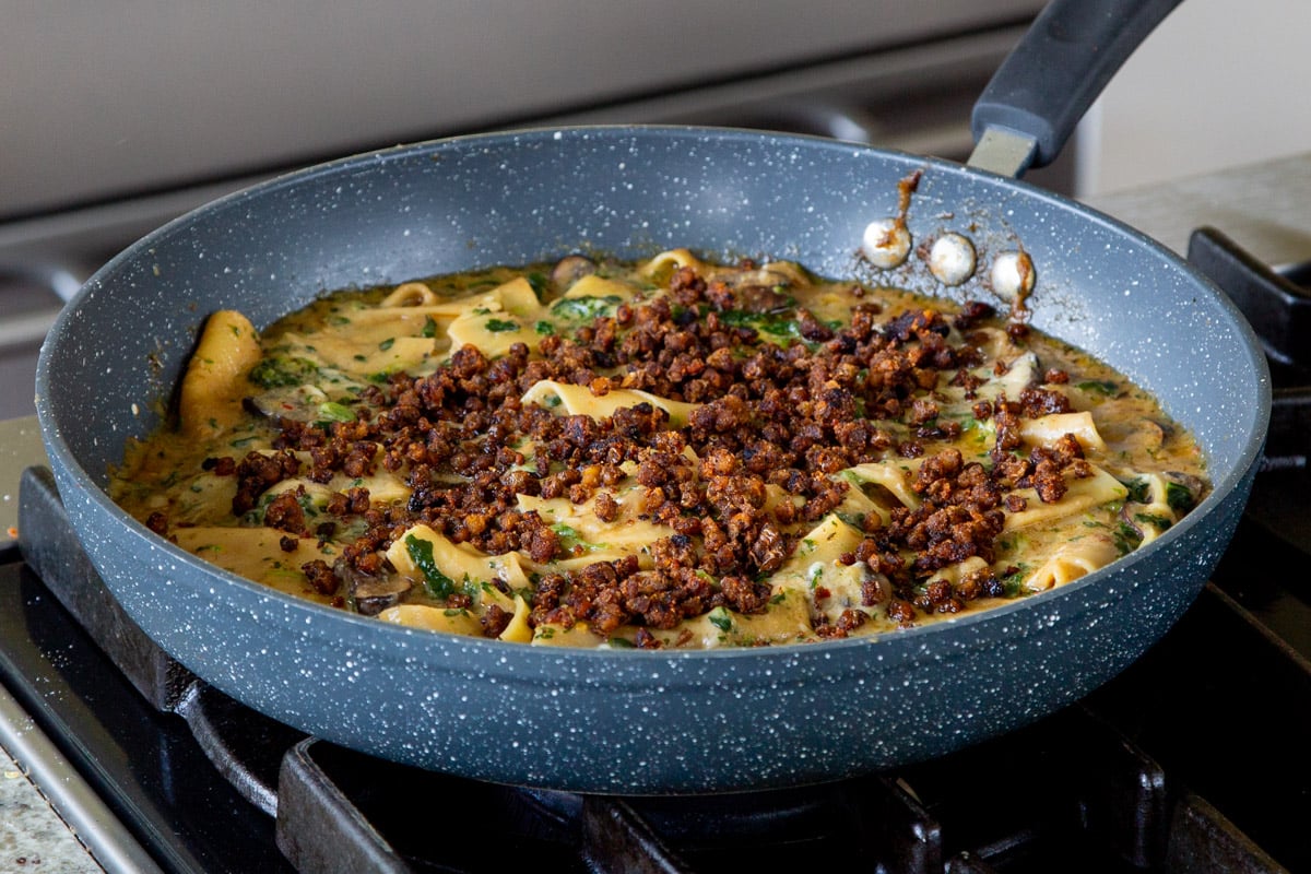 smoky skillet lasagna in the pan, topped with crispy lentils