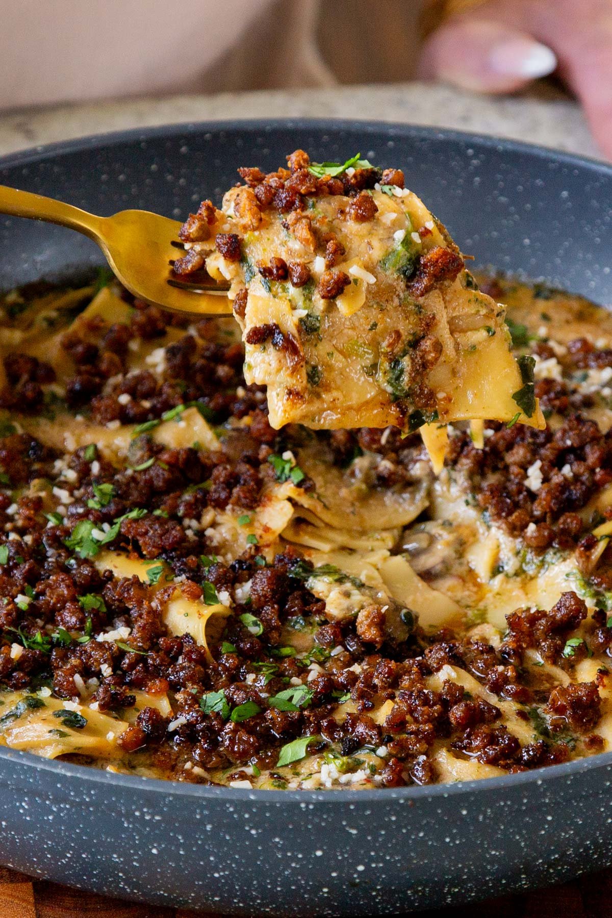 fork taking a bite of smoky skillet lasagna our of the pan