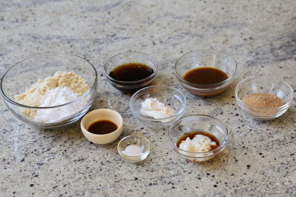 almond flour, maple syrup, coffee, and other tiramisu cookie ingredients in bowls on the kitchen counter
